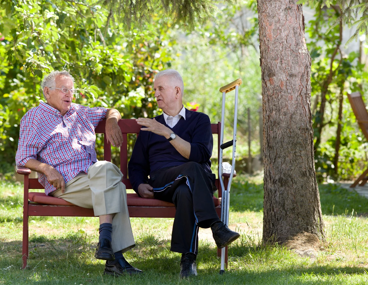 Senior men sitting on bench Two retired men sitting on bench in park